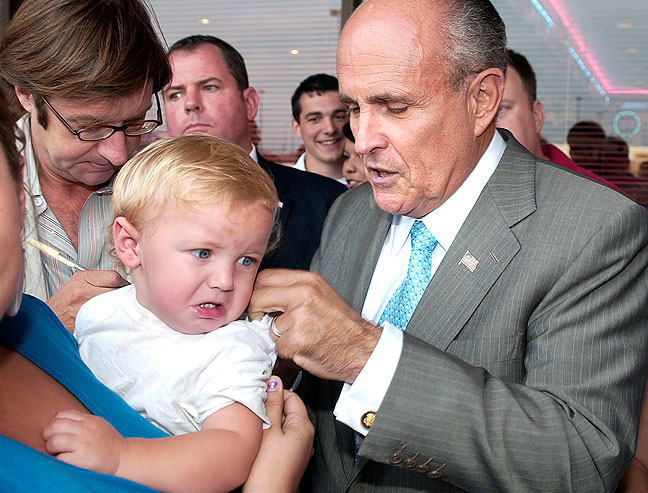 Presidential hopeful Rudy Giuliani signs an unhappy baby's blouse in Ada, spring 2007.