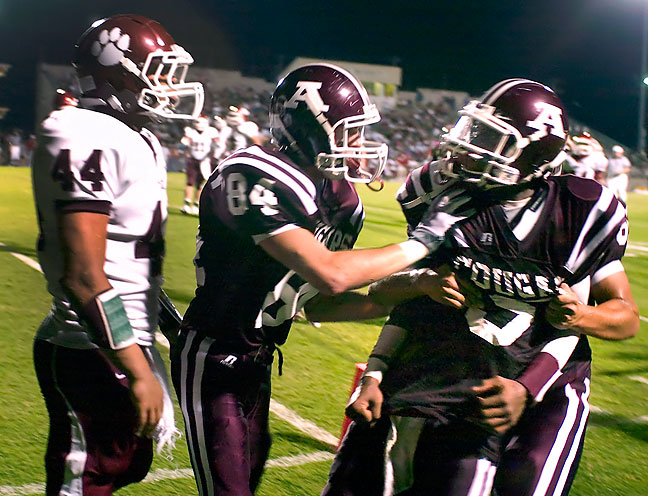 Ada Cougar football players hold their quarterback after words were exchanged with the opposition at the end of a play, September 2008.