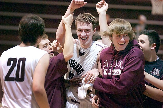 Ada Cougar star athelete Cory Kilby smiles as he is congratulated by his teammates after breaking Ada's all-time scoring record at Ada High School's Cougar Activity Center, Feb. 21, 2015.