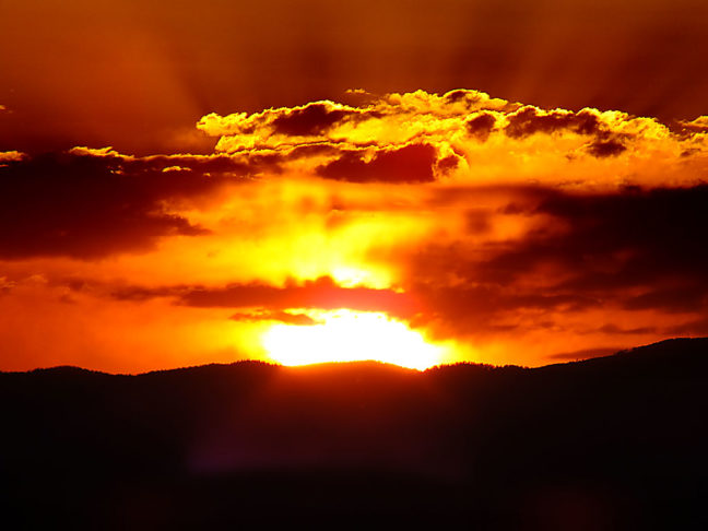 The sun touches the edge of the mountains in this super-telephoto view made with the Fujifilm HS30EXR.