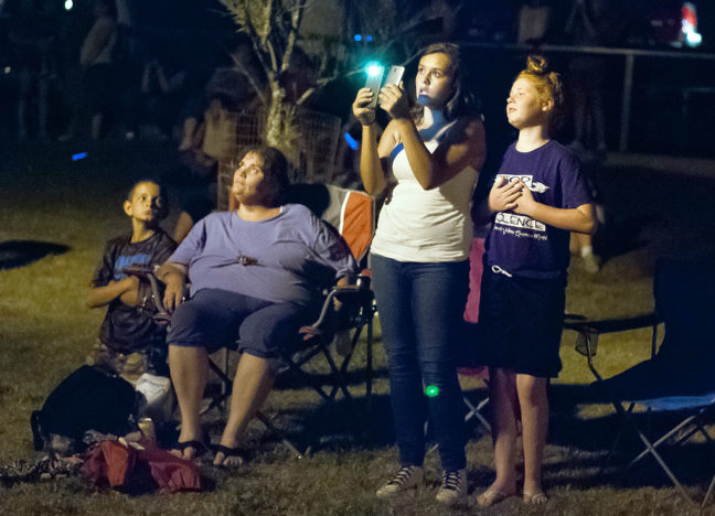 A woman uses a phone to record the fireworks display in Wintersmith Park.