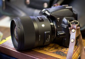 The Sigma 35mm f/1.4 dwarfs the tiny Nikon 3100 digital camera.