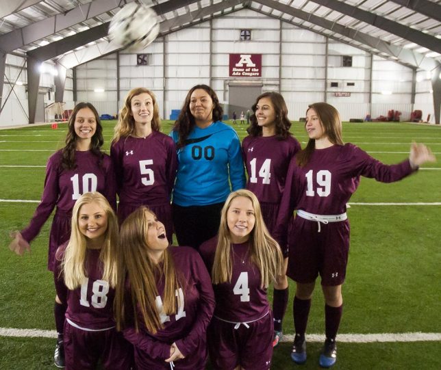 Sadie Criswell, far right, tosses a soccer ball over her fellow senior soccer players at media day today.