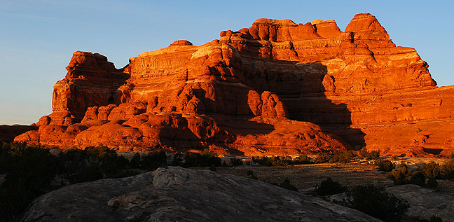 Squaw Butte at Canyonlands takes on red light at sunset.
