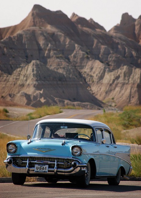 A classic Chevrolet sits by the side of the main road through Badlands National Park.
