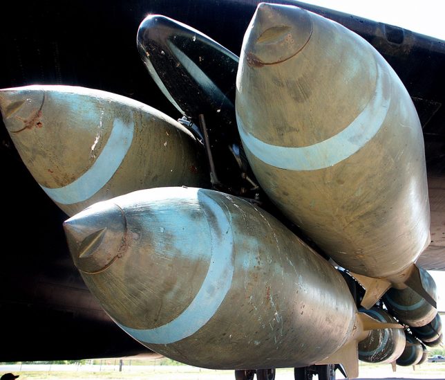 A rack of free fall bombs hangs on the external mount of a Boeing B52 bomber.