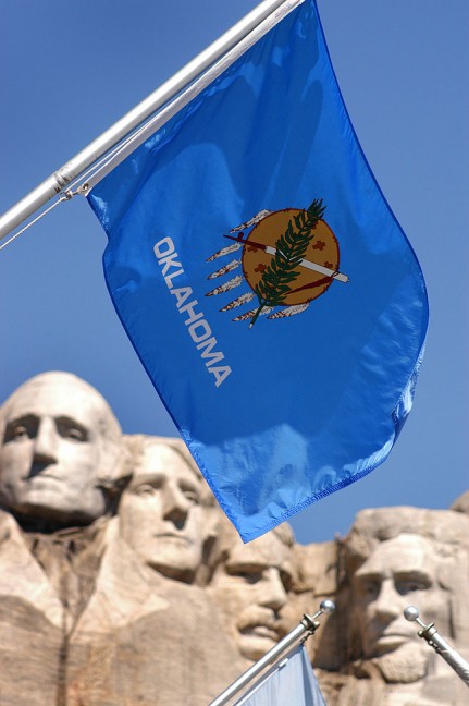 The flags of all 50 U. S. States, including ours, Oklahoma, are displayed at Mount Rushmore.
