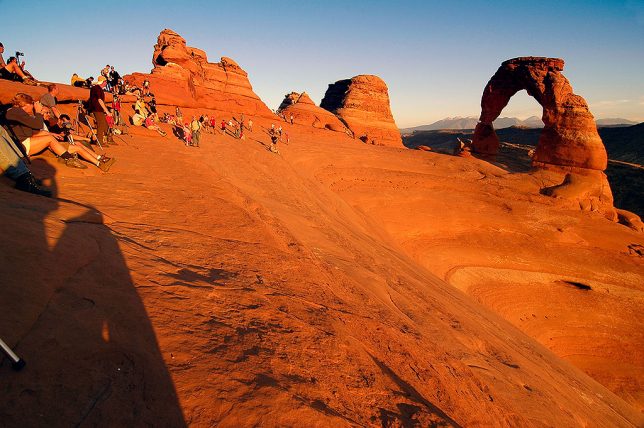 Visitors crowd the Delicate Arch area as sunset approaches.
