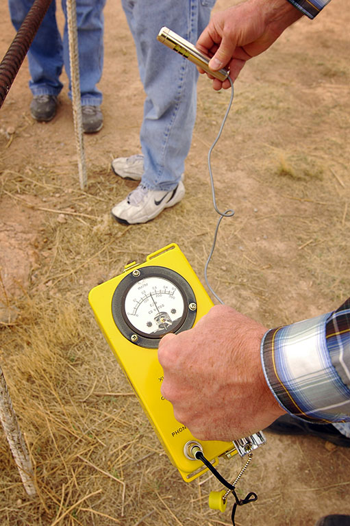 A man uses a geiger counter to measure remnant radiation at the Trinity Site.