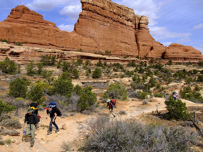 Backpackers pass "The Wall" on the Chesler Park trail at Canyonlands National Park, Utah.