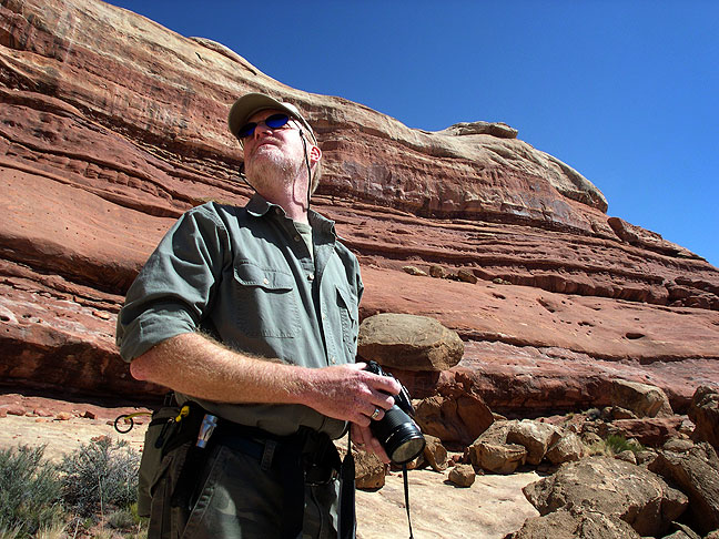 The author looks over a stone wall along the Peek-a-Boo trail.