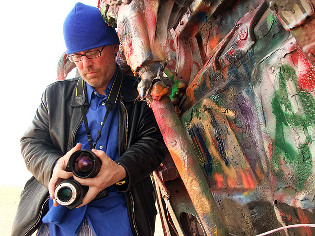 Happy to be shooting Amarillo's colorful Cadillac Ranch, Robert struggles to change lenses while hiding from a stout, dusty wind.