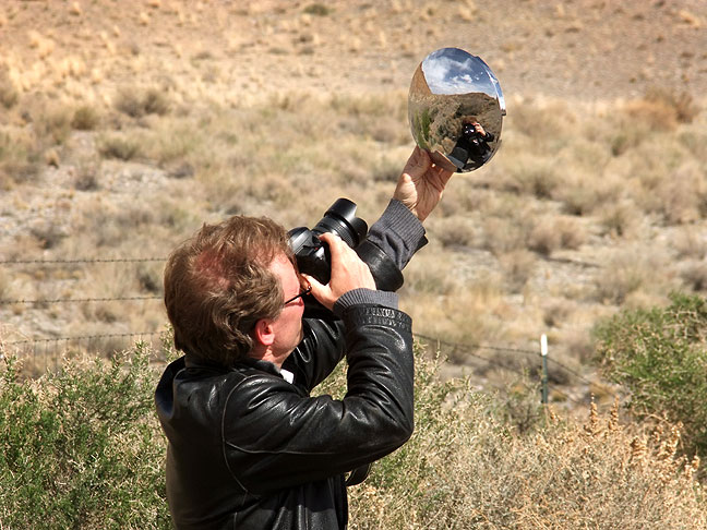 Robert uses a reflective chrome hub cap as he makes pictures near The Hogback in northwestern New Mexico.