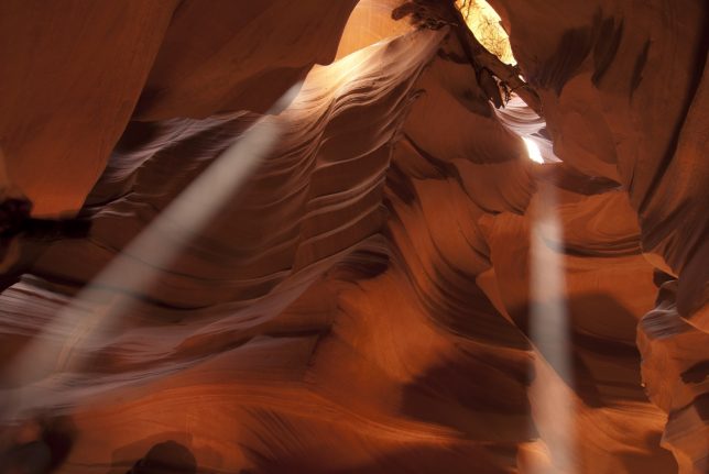 Two shafts of light shine down into Antelope Canyon.