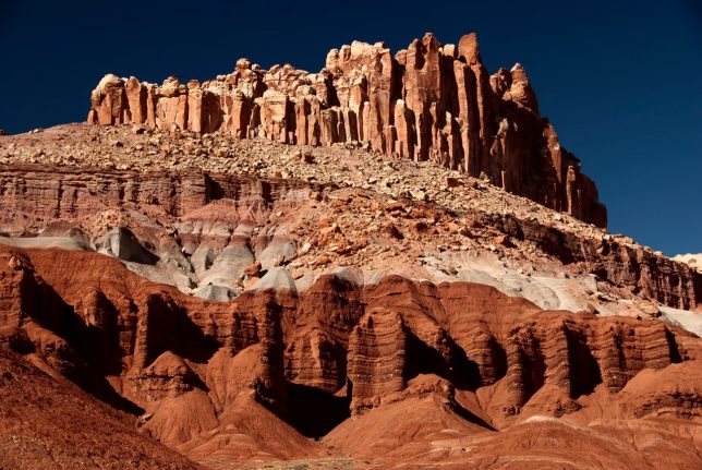 The bold striations of Capitol Reef National Park stand in afternoon sun.
