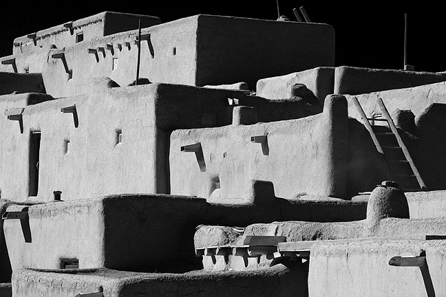 This bold black-and-white rendition of the main structures at Taos Pueblo emphasize its linear construction. Compare to...