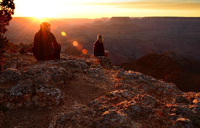 Fellow visitors take in the majesty of the Grand Canyon's Navajo Overlook at sunset.
