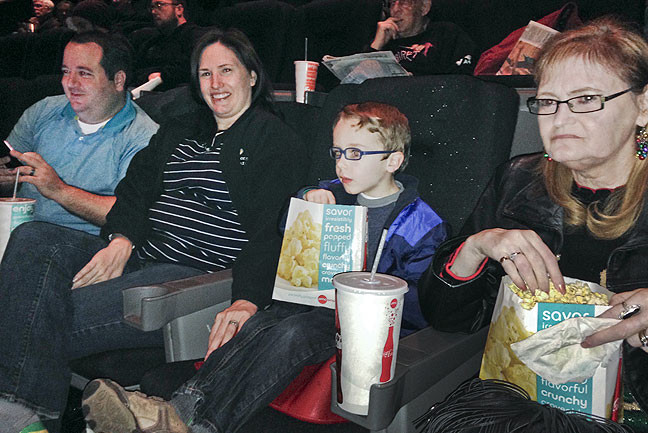 Tom, Chele, Paul and Abby wait for the start of <i>Star Wars: The Force Awakens</i>. The early show was deeply discounted, so Abby's Coke and popcorn cost as much as our tickets.