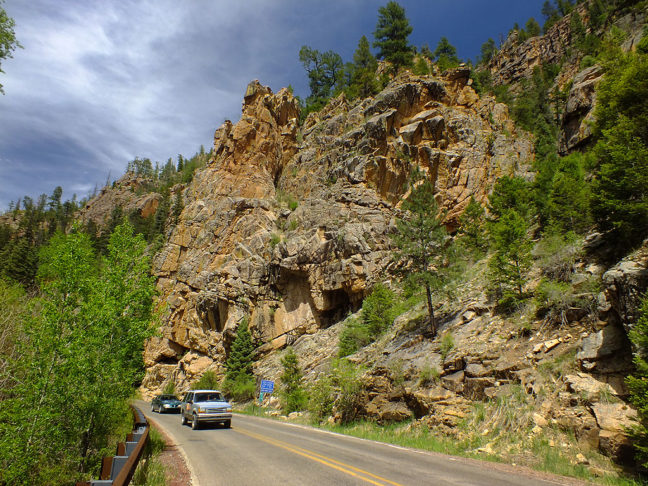 Highway 63 passes several handsome palisades, like this one, with traffic passing to show scale.