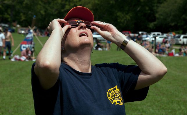 Nicole uses her eclipse glasses to watch as the crescent sun becomes a sliver.