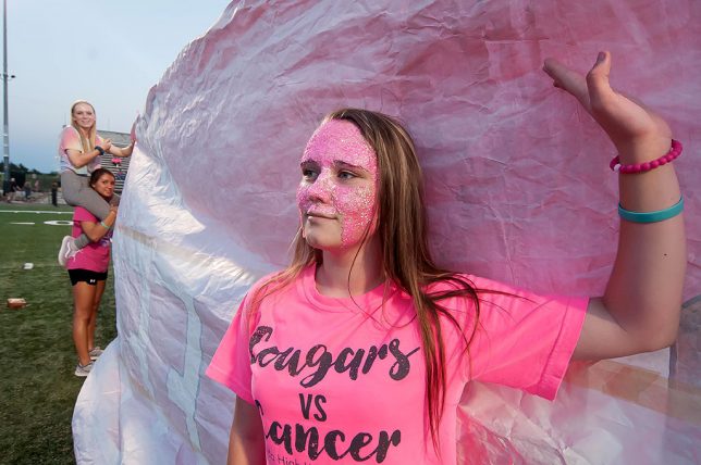 Amelia Holtzman wears pink sparkle makeup for "Pink Out Night" during pregame activities at the Ada football matchup against Bethany Friday night. At first she wanted to pose for me, but I asked her to watch the happenings. I thought it expressed Pink Out Night very nicely.