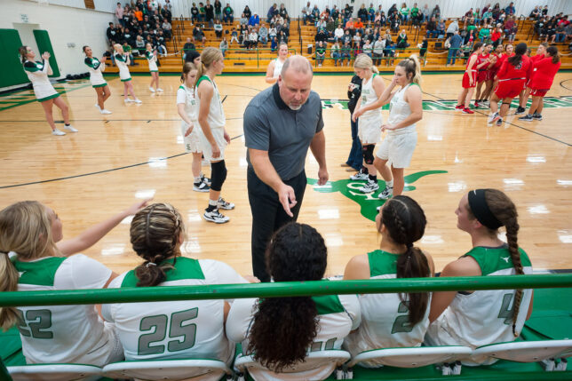 Coach Jeff Parnell talks to his starters prior to the Stonewall Lady Longhorns matchup with Earlsboro Tuesday, Nov. 2, 2021 at Murphy-Roberts Gym in Stonewall. Shot with my 20mm f/2.8 lens on a camera with a 24x36mm sensor, this is one way to "fill up the frame" to convey a complex visual message.