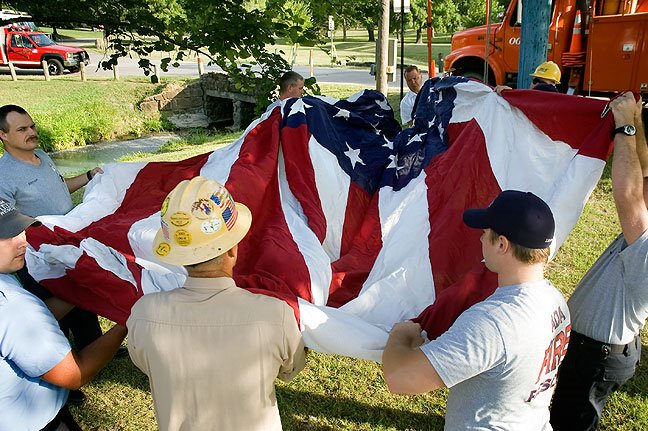 OG&E and the Ada Fire Department raise the giant flag at the entrance to Wintersmith Park