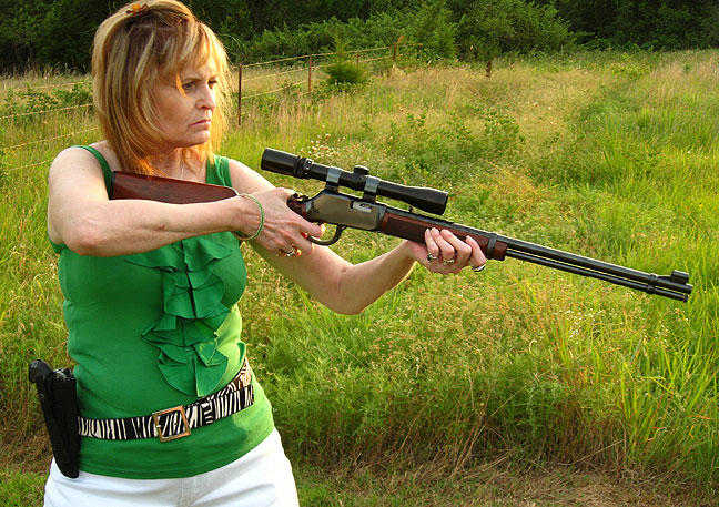 Abby takes aim with her Winchester .22 magnum rifle; the scope is a 3x-9x zoom; note the Walther P22 on her side.