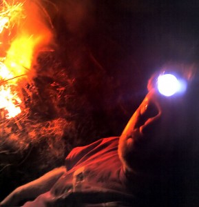 With fruit tree branches and last year's tomato vines burning behind me, I appear ghostly wearing my headlamp.