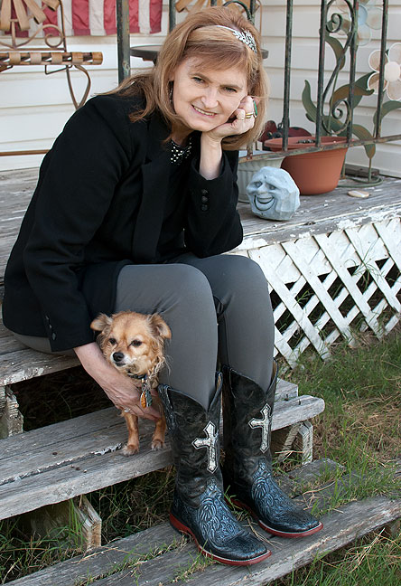 Abby poses on our front porch tonight, petting her Chihuahua Sierra and wearing her black boots.
