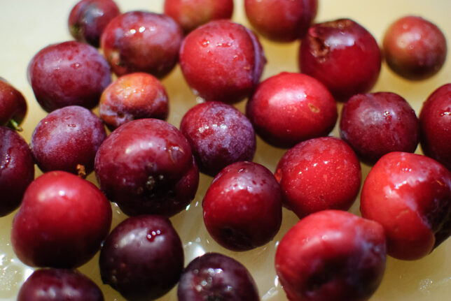 Small, ripe plums sit on my cutting board tonight.