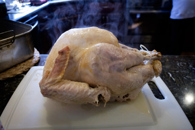 A steaming turkey sits on a cutting board.