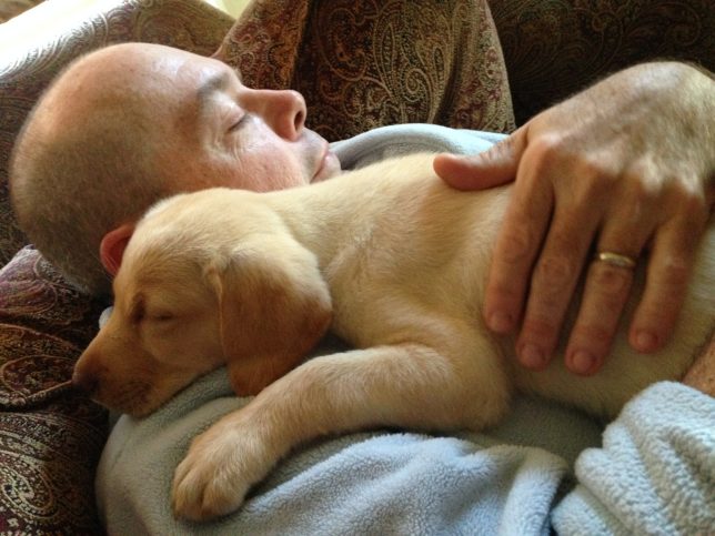 My brother-in-law Tracey sleeps with their new puppy Dauphine nine years ago.