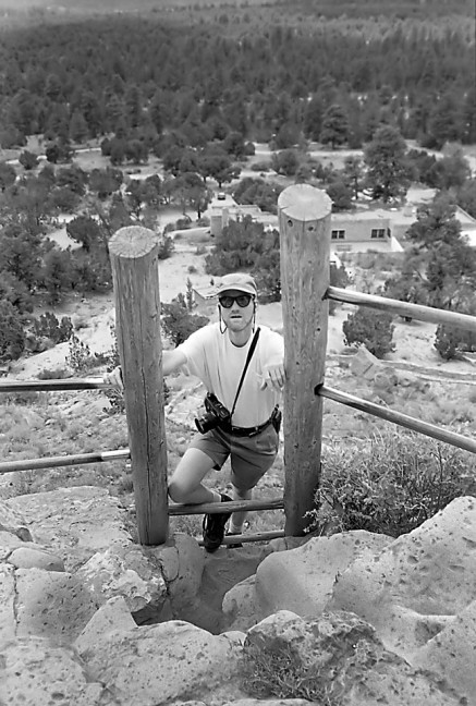 The author climbs a short ladder at Puyé Cliff Dwellings. Note my Fuji 6x7 medium format camera.