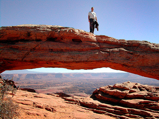 David strolls across Mesa Arch in the Island in the Sky district at Canyonlands.