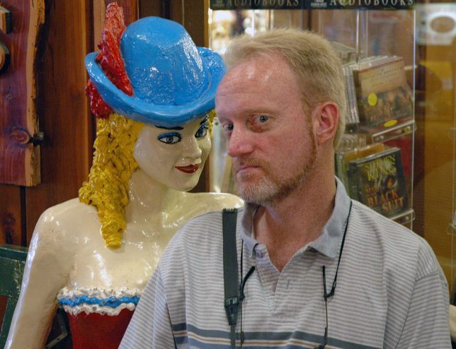 The author poses with a life-size statue of a burlesque performer at Wall Drug.