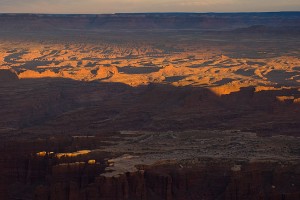 A streak of light crawls across the complex formations below Grand View Point, Canyonlands.