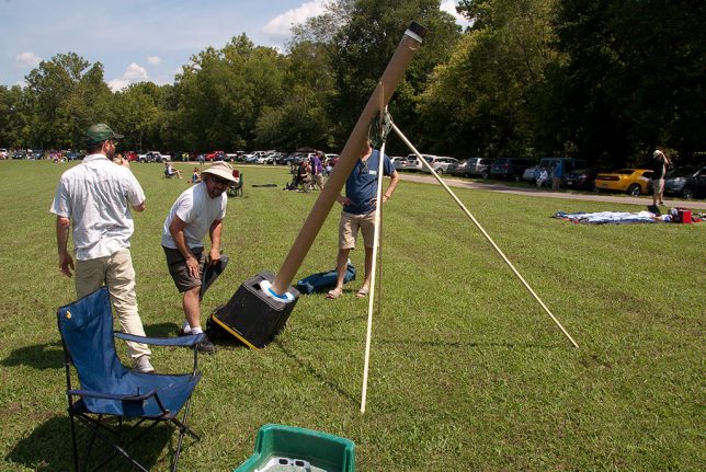 Amateur astronomers from Chicago set up a solar pinhole observatory made from a discarded carpet roll core. The viewing hood is a plastic storage bin.