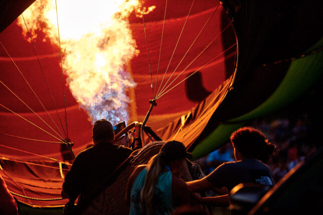 A balloon crew fires a propane burner to inflate their craft in preparation for the "balloon glow" portion of the Fire Lake Balloon Festival.